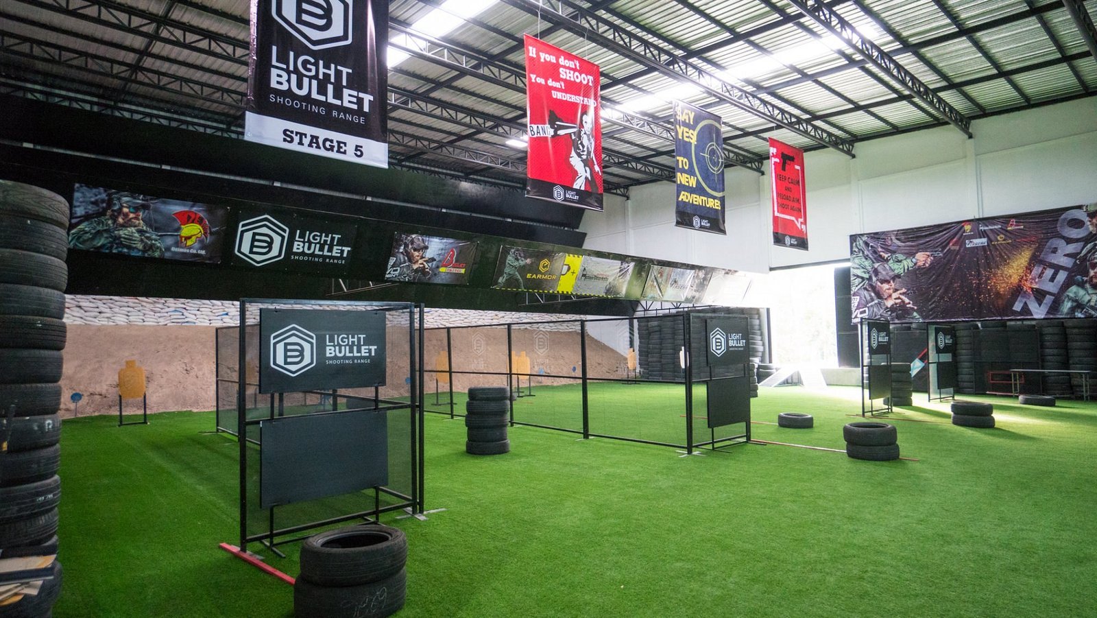 Indoor move-and-shoot action bay with barriers and turf at Light Bullet