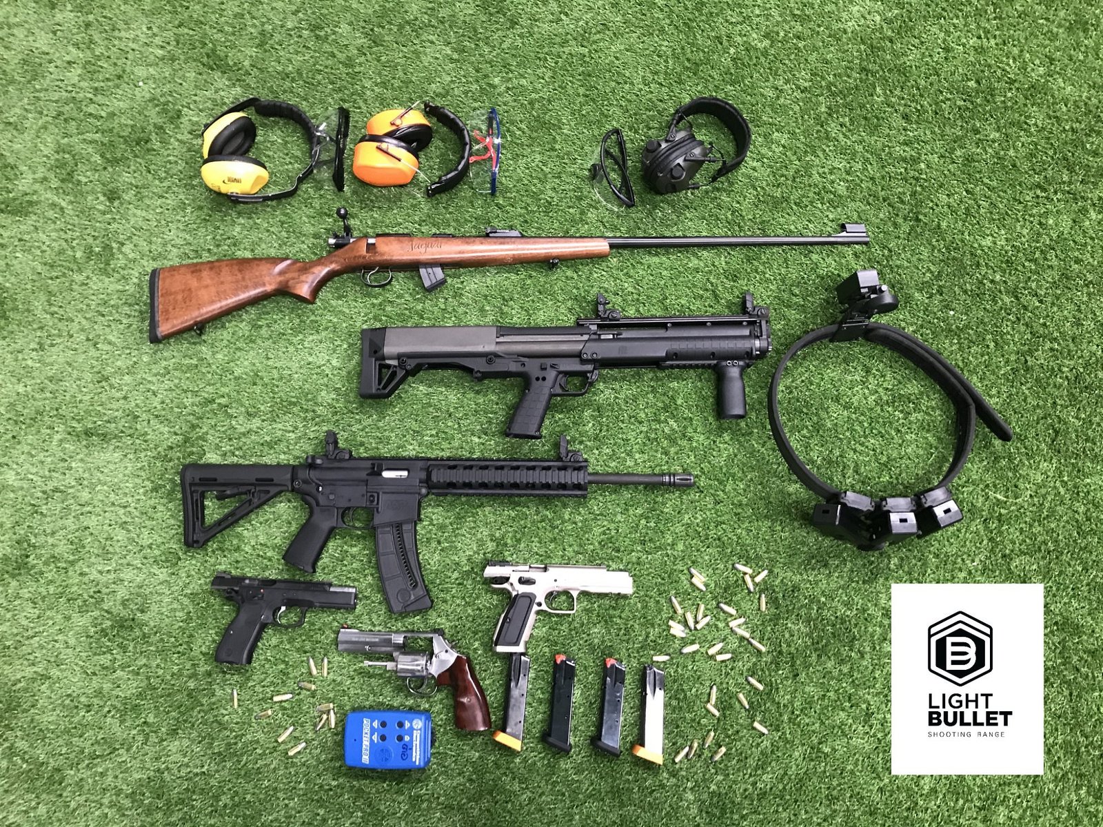 A selection of Light Bullet firearms with ear and eye protection laid out on the range
