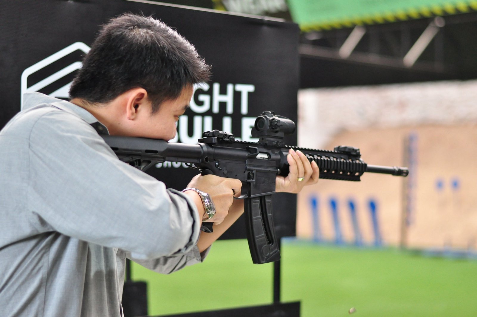 A visitor aiming a rifle at the Light Bullet indoor range